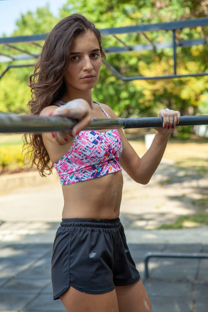 Giovane donna bruna sexy sportiva che fa esercizi sul terreno sportivo. Concetto stile di vita sano
. - Foto, immagini