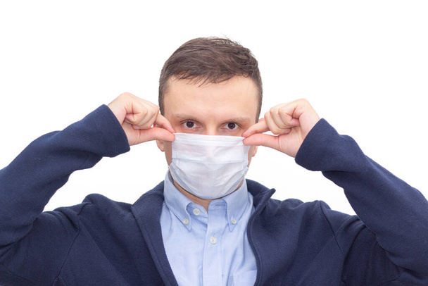 Portrait of a man on a white isolated background, face covered with a medical mask, banner for text. Health, awareness, and timeliness. Healthy lifestyle. No viruses. - Zdjęcie, obraz