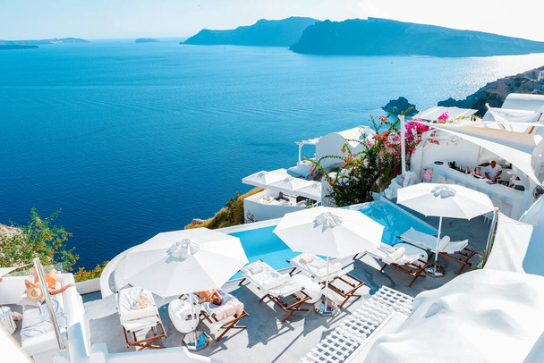 Santorini Oia Köyü günbatımında beyaz oteller ve Santorini Adası 'ndaki beyaz boyalı binalar Yunanistan' da lüks bir tatil beldesi. - Fotoğraf, Görsel
