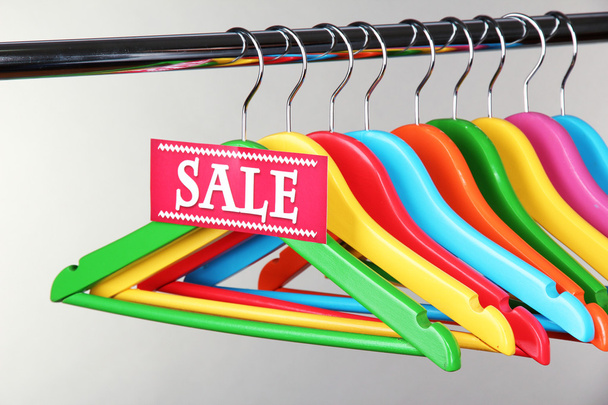 Wooden clothes hangers as sale symbol on gray background - Foto, immagini