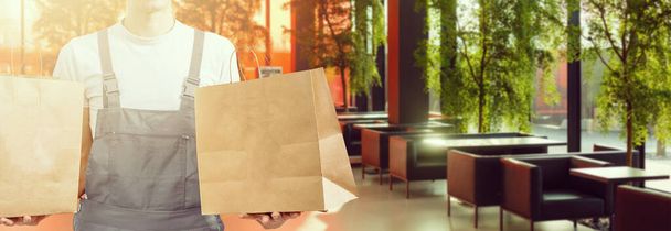 entrega, correo y concepto de personas - hombre feliz entrega de alimentos en bolsa de papel desechable a casa del cliente - Foto, Imagen