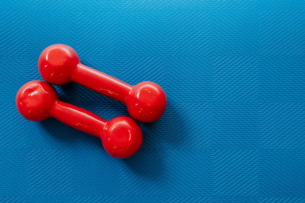 Kurzhanteln für Fitness liegen auf einer Trainingsmatte - Foto, Bild