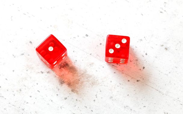 Two red craps dices showing Easy Four (number 1 and 3) overhead shot on white board - Photo, Image