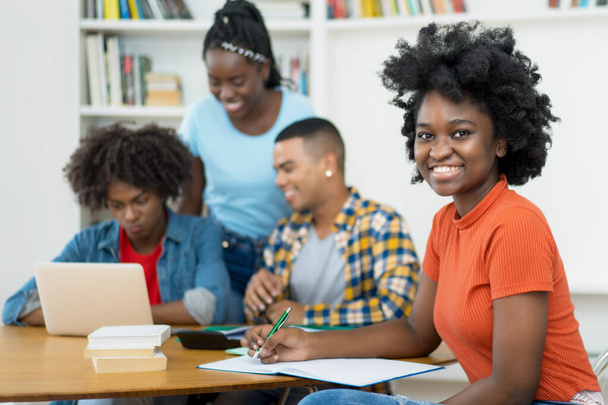 African american female computer science student with group of students at classroom of university - 写真・画像