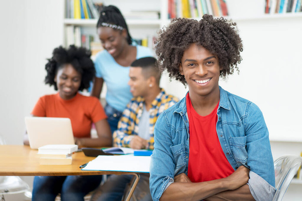 Young african american computer science student with group of students at classroom of university - Fotografie, Obrázek