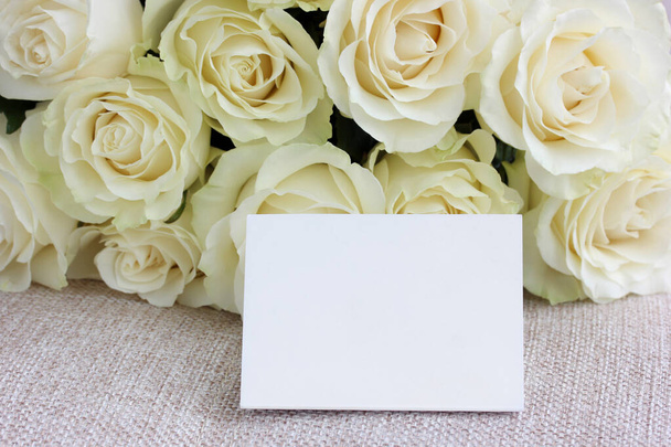 mockup, an empty cardboard card against a background of delicate cream roses. floral backdrop, greeting card. space for Your text. - Fotó, kép