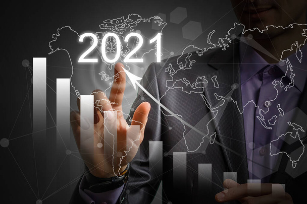 Man's hand pointing graph of success in 2021 year. Growing business concept - Photo, Image