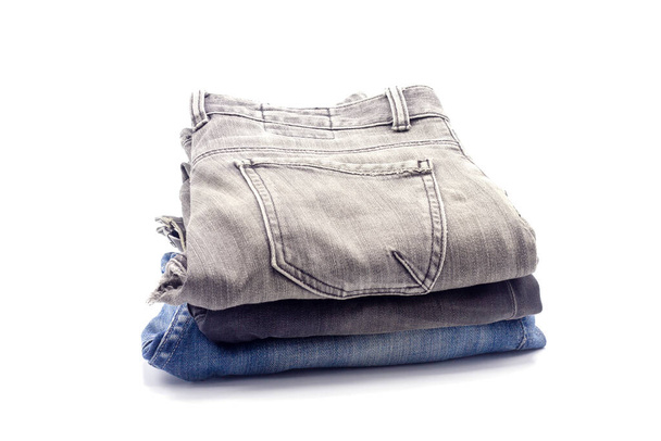 Jeans gestapeld op een witte achtergrond - Foto, afbeelding