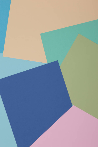 Blue, green, yellow and pink background, colored paper geometrically divides into zones, frame, copy space. - Foto, afbeelding