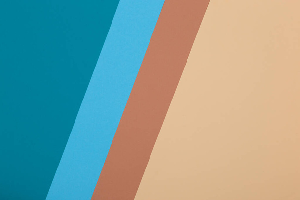 Blue, brown and yellow background, colored paper geometrically divides into zones, frame, copy space. - Foto, afbeelding
