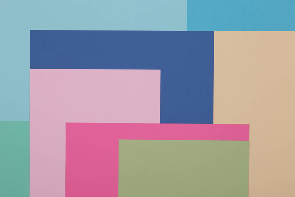 Blue, green, yellow and pink background, colored paper geometrically divides into zones, frame, copy space. - Zdjęcie, obraz