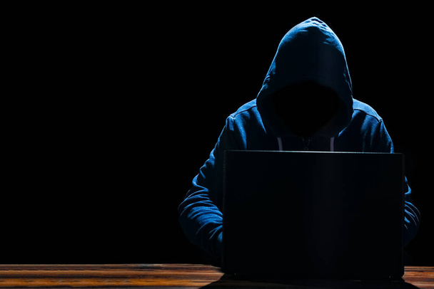 Хакер з ноутбуком за столом врізається в систему
 - Фото, зображення