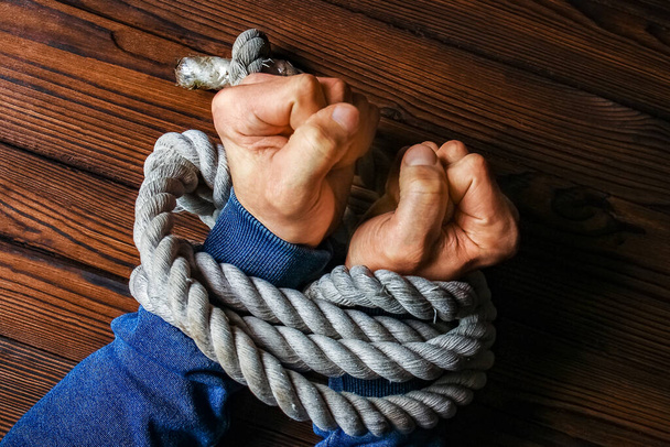 hands with a rope on a wooden background - Photo, Image