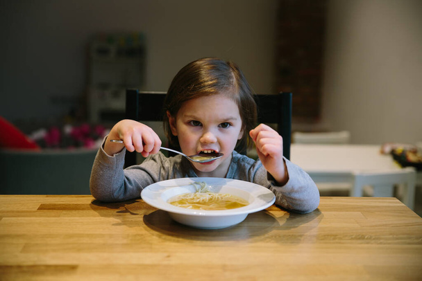Bambina con una ciotola di zuppa di pasta
 - Foto, immagini