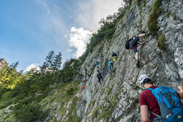Hiking and climbing on the Tegelberg via the via ferrata at Neuschwanstein Castle in the Ammergau Alps near Schwangau - Фото, изображение