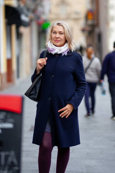 mature woman tourist walks the streets of the town - Фото, зображення