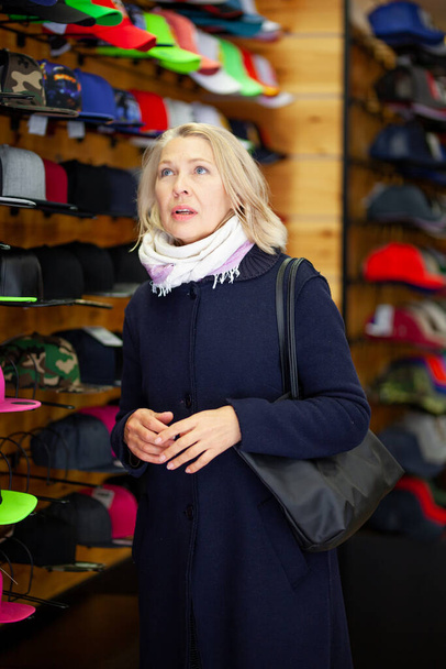 mulheres em uma loja de chapéu escolhe um chapéu
. - Foto, Imagem