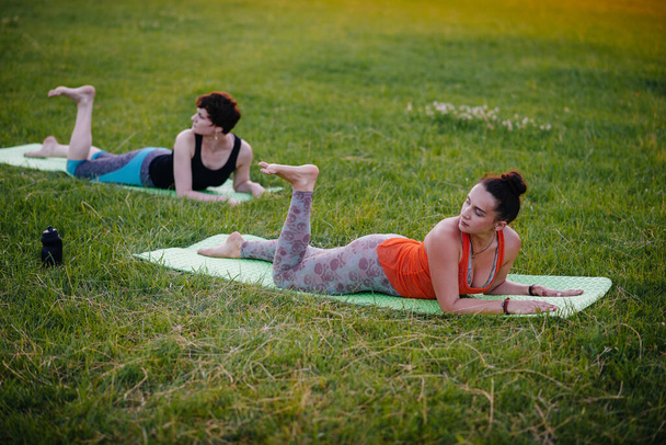 Young girls do yoga outdoors in the Park during sunset. Healthy lifestyle - Foto, Bild