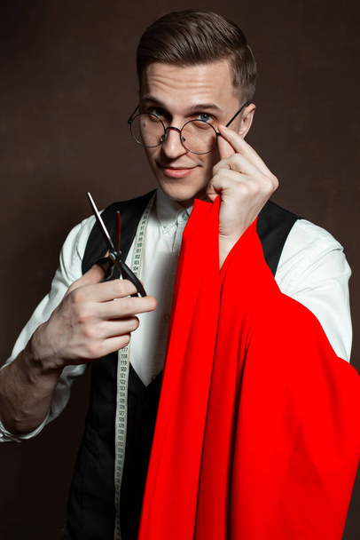 tailor man in round glasses and classic clothes with red cloth - Фото, зображення