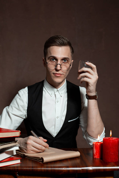 man in round glasses with writes a book - Fotografie, Obrázek