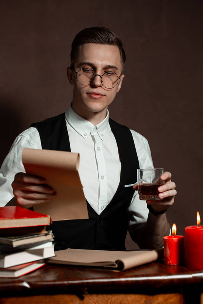 man in round glasses with writes a book - Fotoğraf, Görsel