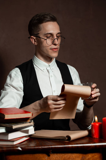 man in round glasses with writes a book - Fotoğraf, Görsel
