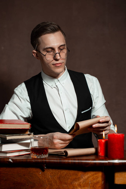 man in round glasses with writes a book - Фото, изображение