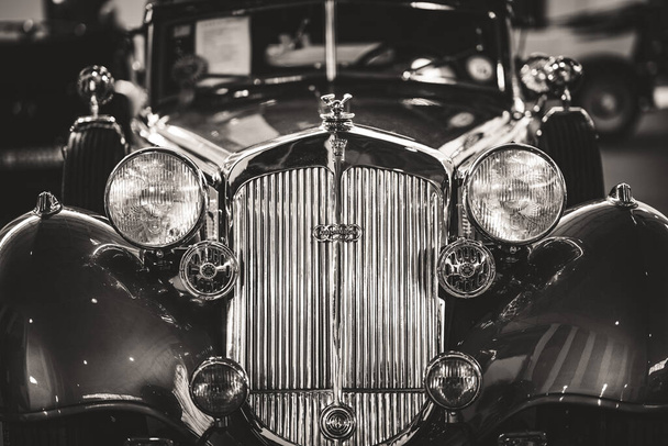 Voorzijde van de grille en koplampen van een cabriolet sportwagen in zwart-wit - Foto, afbeelding