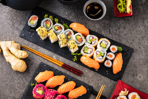 top view of delicious sushi set with ginger, wasabi, soy sauce and chopsticks  - Φωτογραφία, εικόνα