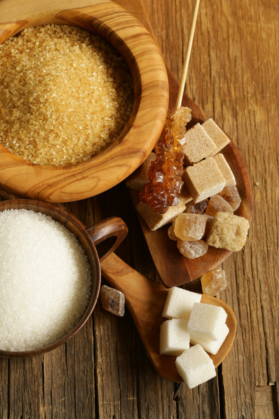 Different kinds of sugar - brown, white, refined sugar on a wooden background - Photo, Image