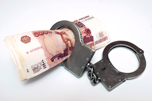 Banknotes and metal handcuffs - Foto, afbeelding