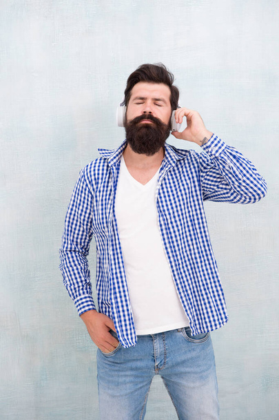 music is my life. hipster man wear headphones. inspired by quality of sound. listen play list outdoor. listens to music in wireless headphones. trendy bearded man. man enjoy favorite song - Photo, Image