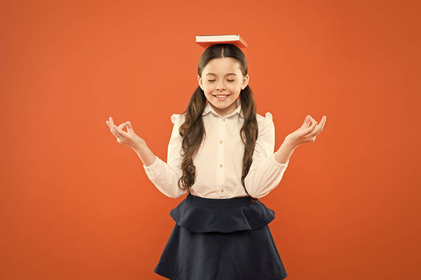 Meditation. Girl child hold book. School girl studying textbook. Kid school uniform hold book. Excited about knowledge. Life balance and positivity. Dealing with school stress. Excellent first former - Фото, изображение