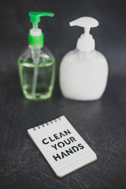 keep your hands clean to fight bacteria and viruses conceptual still-life, hand sanitizer and liquid soap next to memo with Clean your Hands text - 写真・画像