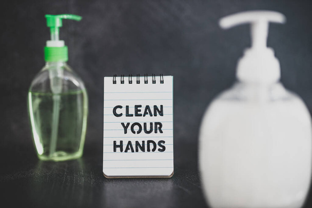 keep your hands clean to fight bacteria and viruses conceptual still-life, hand sanitizer and liquid soap next to memo with Clean your Hands text - 写真・画像