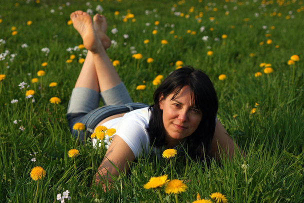 young woman lying on grass in the meadow - 写真・画像