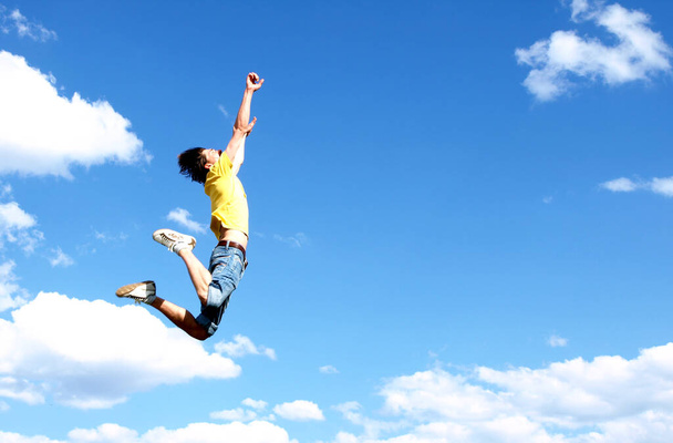 young man jumping on the sky background - Φωτογραφία, εικόνα