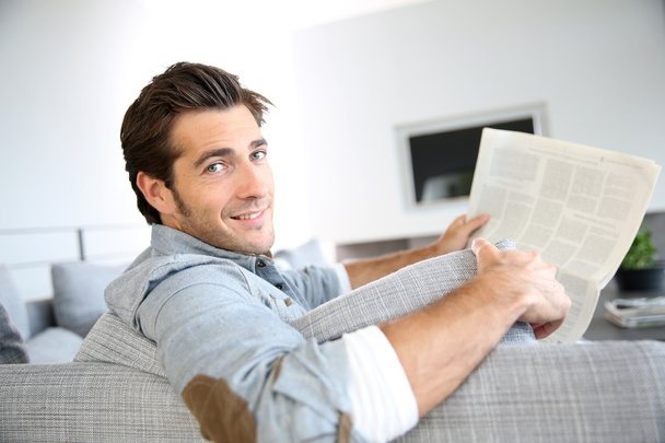 Guy at home reading newspaper - Photo, Image