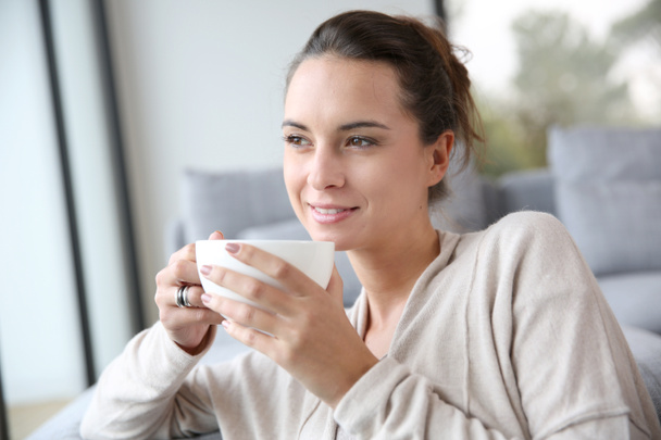 Donna che si rilassa a casa con una tazza di tè
 - Foto, immagini