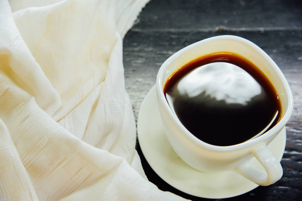 Espresso ve skleněné a bílé látce na černém dřevěném stole, pohled shora - Fotografie, Obrázek