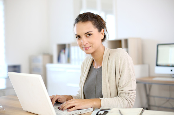 Woman working in office on laptop - Foto, immagini