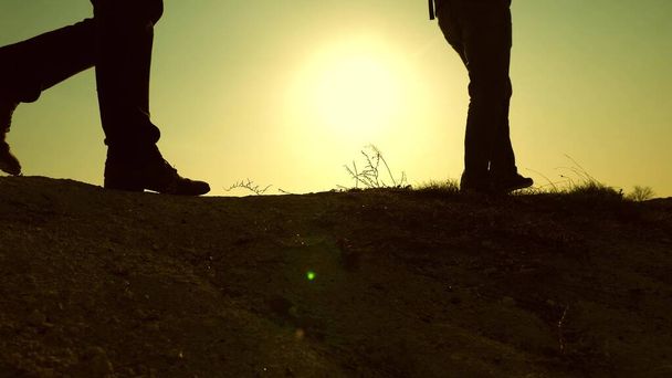 Ludzie pracy zespołowej. stopy Free Travelers poszukiwacze przygód chodzić wzdłuż szczytu góry w promieniach pięknego słońca. turysta podróżuje po górach o zachodzie słońca. dążenie do zwycięstwa i sukcesu. - Zdjęcie, obraz