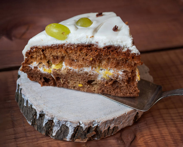 Serving of homemade cake with sour cream and fruit on a wooden cut - Foto, immagini