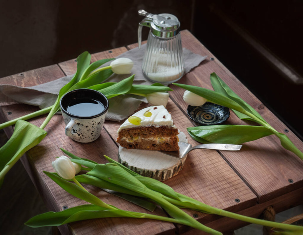 Feestelijke lans met cake en witte tulpen op een houten tafel - Foto, afbeelding