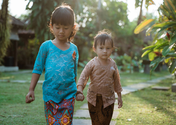 Mutluluk iki güzel kız geleneksel java kebaya giyer ve birlikte yürürken el ele tutuşurlar. - Fotoğraf, Görsel