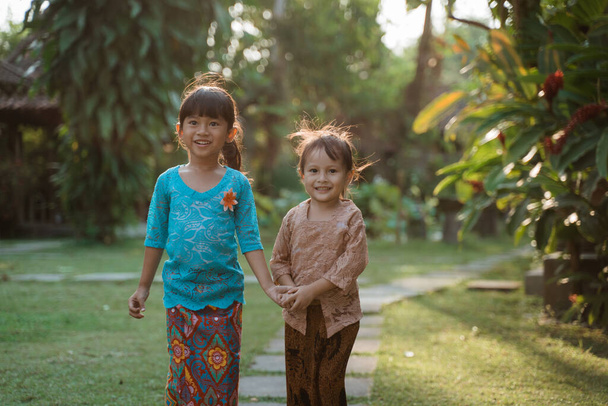 felicità due bella ragazza che indossa kebaya tradizionale giavanese con tenersi per mano quando si cammina insieme
 - Foto, immagini