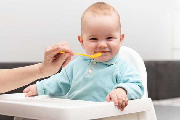 Mother Feeding Her Baby Son With Spoon - Mother Giving Healthy Food To Her Adorable Child At Home - Fotoğraf, Görsel