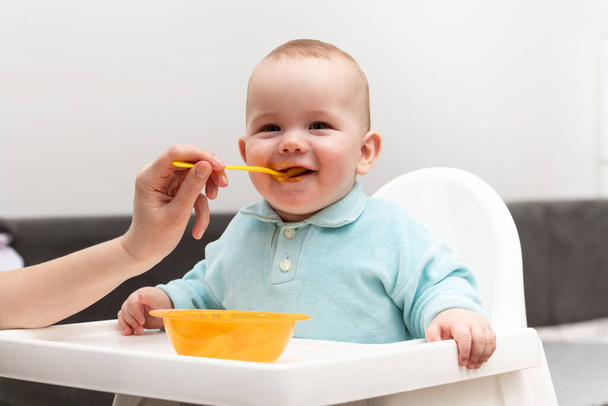 Mother Feeding Her Baby Son With Spoon - Mother Giving Healthy Food To Her Adorable Child At Home - Foto, Bild