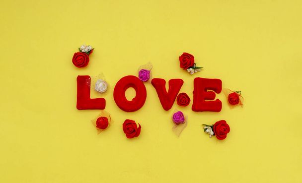 Love word on a yellow background. Top view. Valentines day, mothers day, holiday. - Φωτογραφία, εικόνα