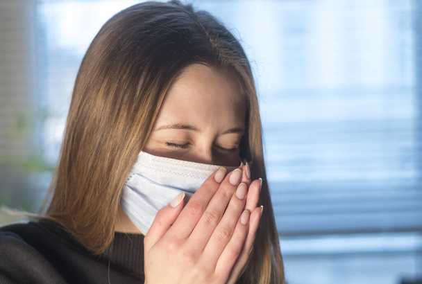 Запобігти поширенню хвороби Коронавірусу 2019 (Ковід-19). Молода жінка чхає або кашляє у захисній медичній масці.  - Фото, зображення